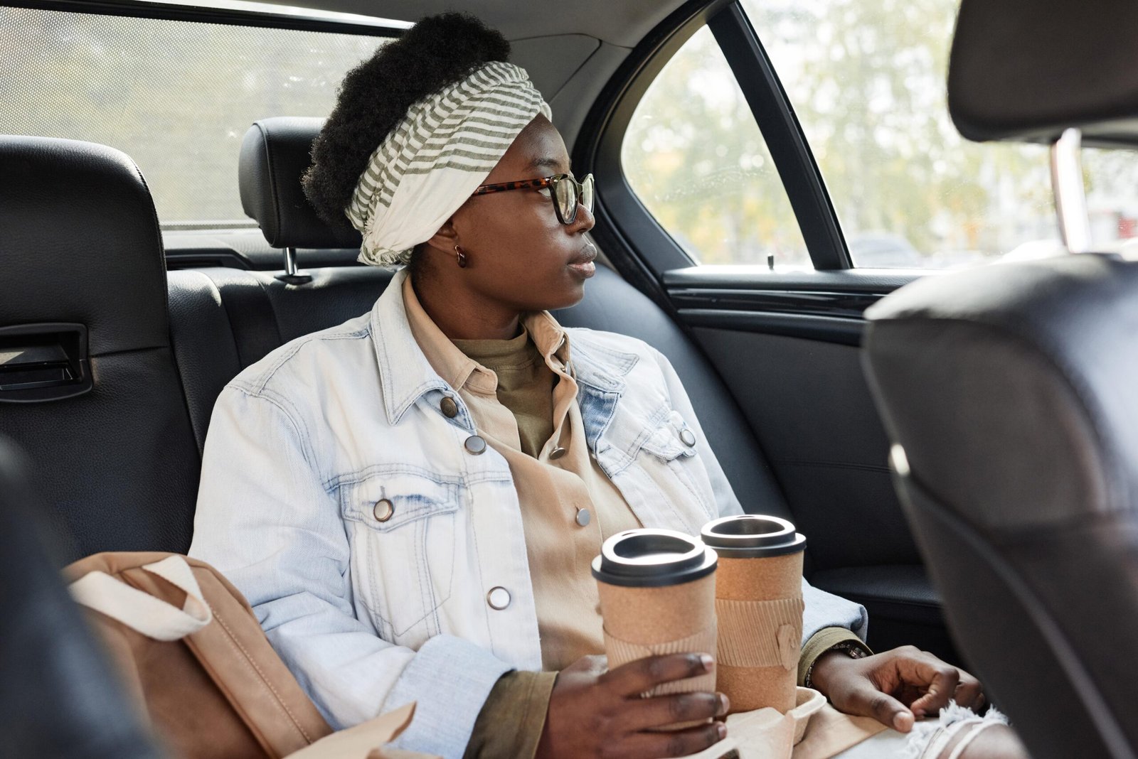 woman-with-coffee-sitting-in-taxi-min